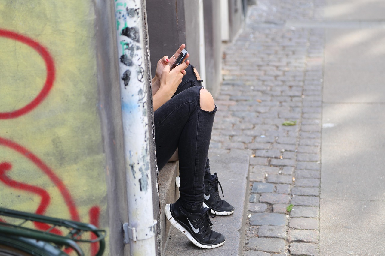 Muž maže zprávu v aplikaci WhatsApp na telefonu