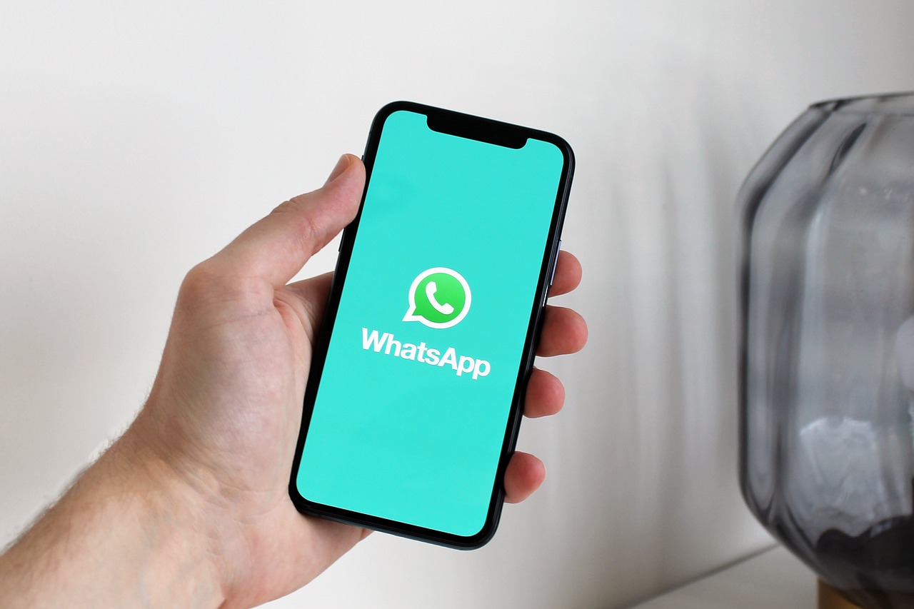 Ruka držící smartphone s otevřenou galerií fotek