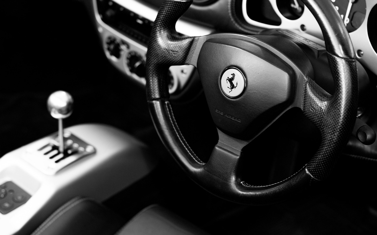 Detailní pohled na moderní V12 motor Ferrari s viditelnými komponenty a karbonovými prvky