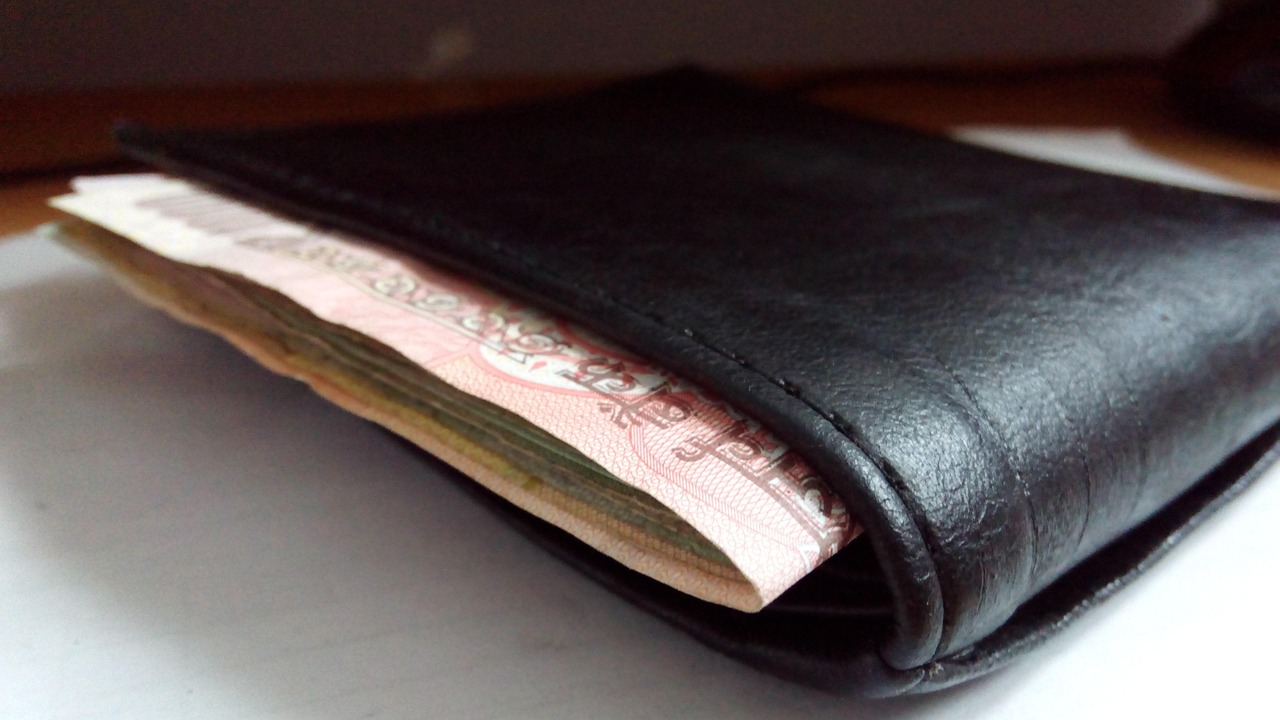 Mladá žena s kalkulačkou a prasátkem, plánující finance