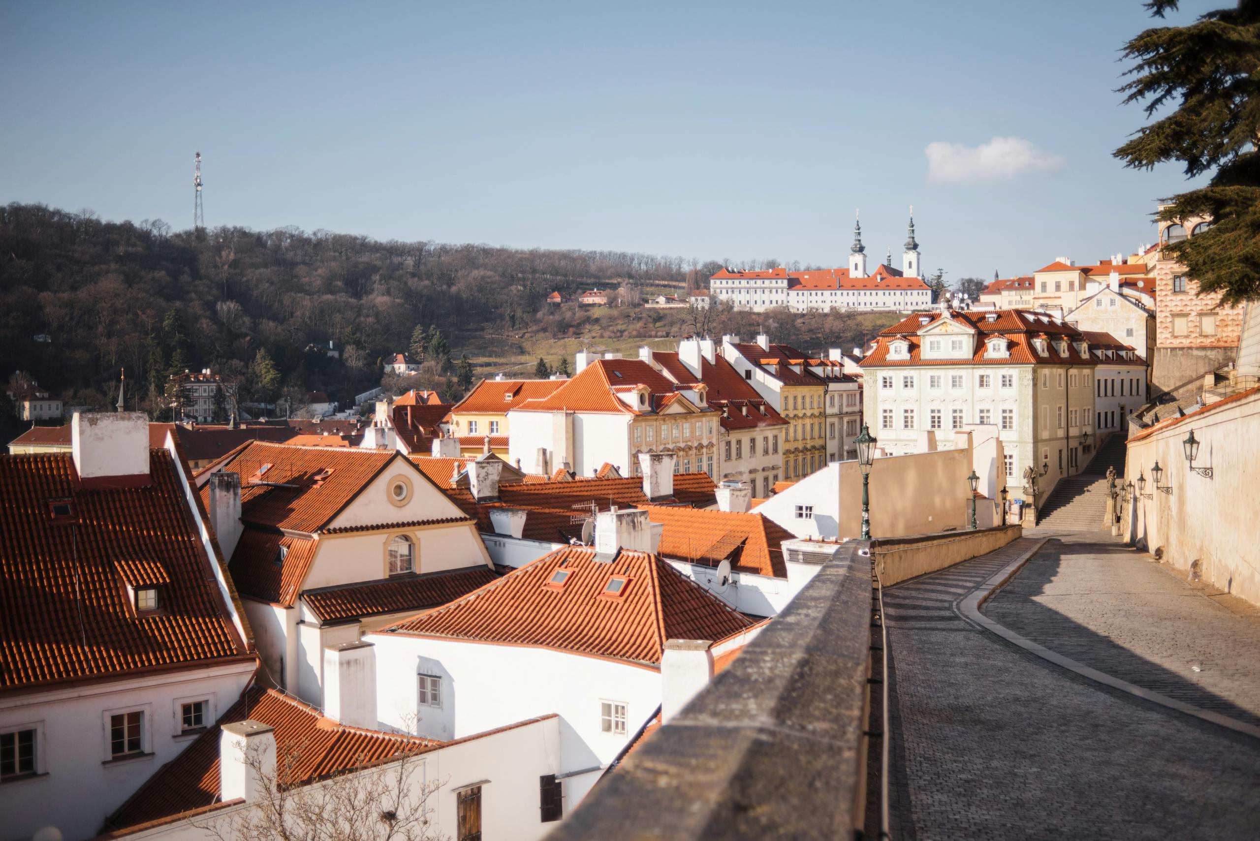 Scenic view of Prague's historic rooftops and streets in autumn.